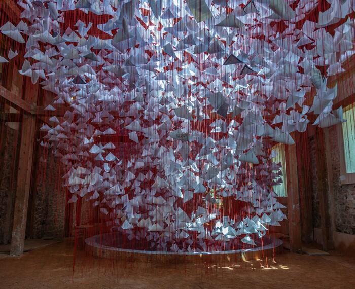 An Art Installation of paper suspended by red thread